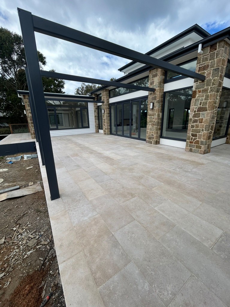 Restored limestone paving at a modern Melbourne home with stone columns by Claraseal