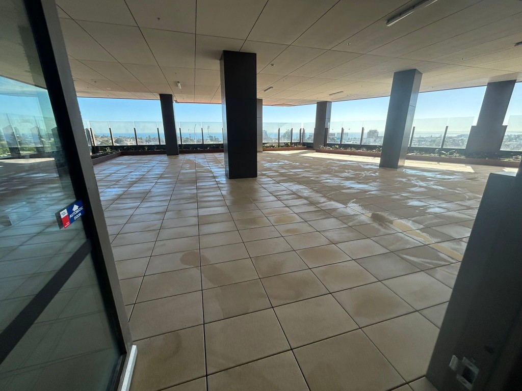 Sealed terracotta tile commercial rooftop terrace overlooking the bay