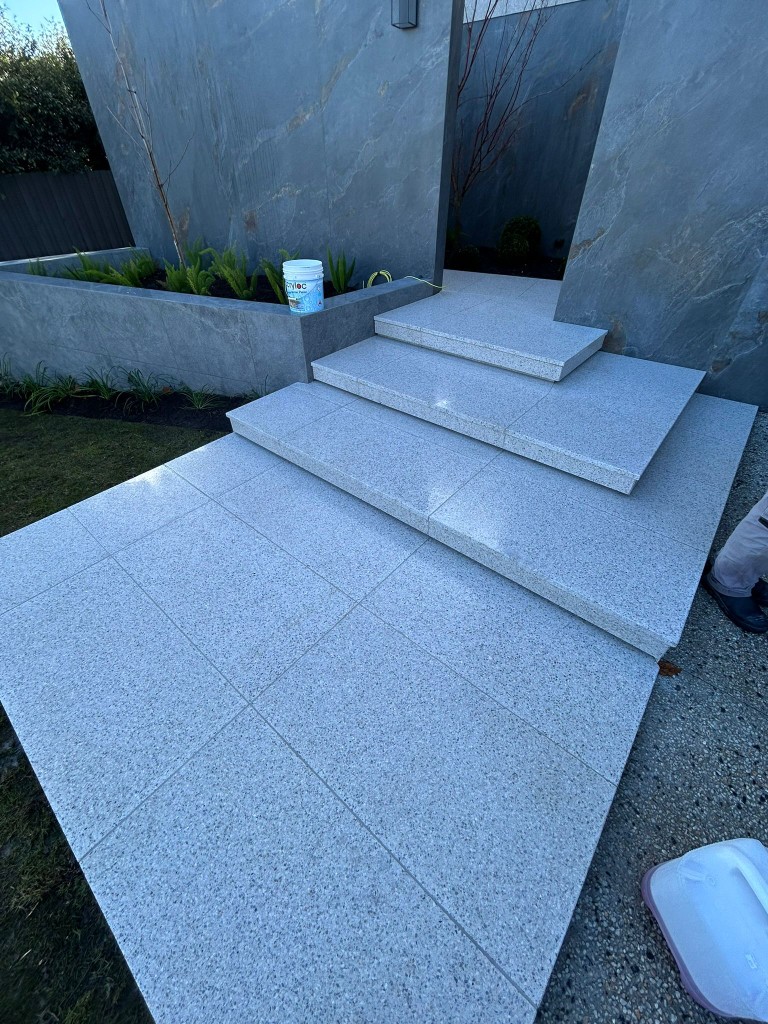 White granite-look paving and steps at modern home entry