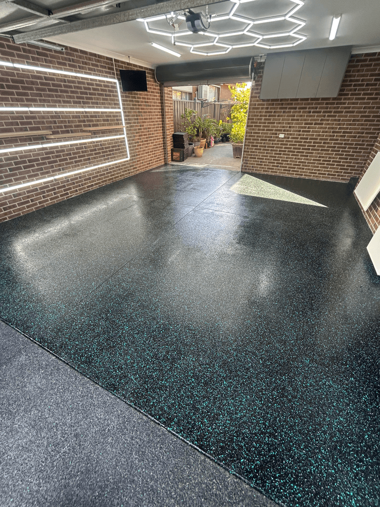 Black and teal metallic flake epoxy garage floor under hexagonal LED lighting at Melbourne home